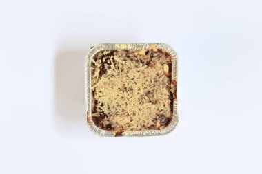 Çikolatalı kek beyaz arka planda peynir serpiştirilmiş.