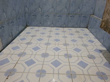 Mavi ve beyaz zemini olan banyo.