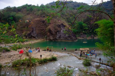 Yogyakarta, Endonezya - 3 Ağustos 2023: Suyun çok temiz ve yeşil olduğu nehir manzarası. İnsanlar Kedung Jati Parang, Selopamioro 'da kano yapıyor..