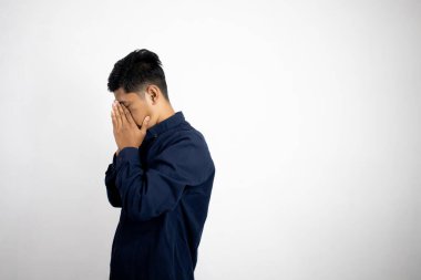 Asyalı adam beyaz arka planda üzgün