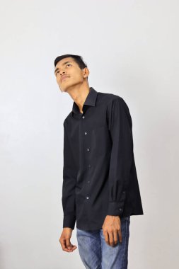 Beyaz bir arka planda endişeli yüz ifadesi olan Endonezyalı bir adam.