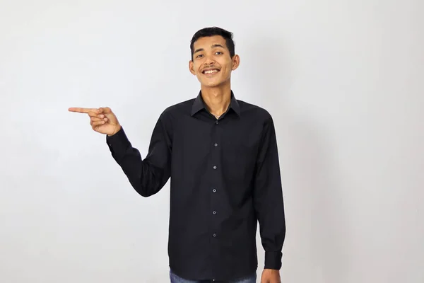 Mladý Pohledný Asijský Muž Ukazuje Prstem Stranu Usmívá Prezentuje Produkt — Stock fotografie