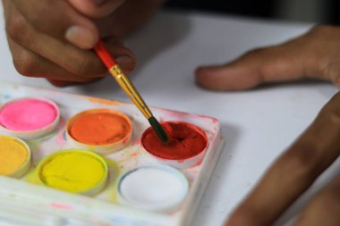 Sanatçı elleri renk paleti ile görüntüyü kapat