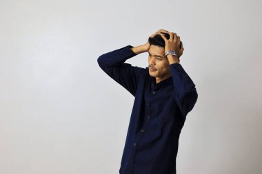 Asyalı yakışıklı bir iş adamı, izole edilmiş beyaz bir altyapının başında gergin bir ifadeyle duruyor..