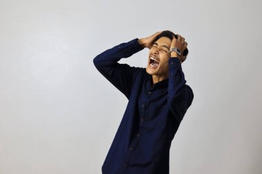 Asyalı yakışıklı bir iş adamı, izole edilmiş beyaz bir altyapının başında gergin bir ifadeyle duruyor..