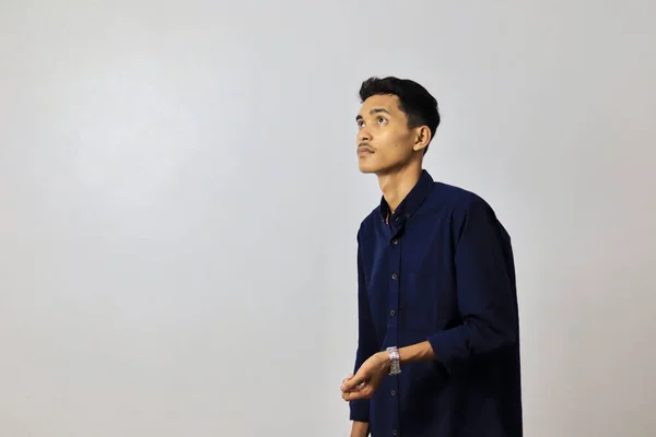 年轻英俊的亚洲男人穿着蓝色的衬衫 背景是孤立的白色 免版税图库照片