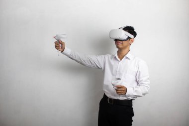 Beyaz gömlekli genç adam sanal gerçeklik kulaklığı kullanıyor. Beyaz arka plan stüdyo resminde izole edilmiş. VR, gelecek, cihazlar, teknoloji, çevrimiçi eğitim, öğrenme, video oyunu konsepti
