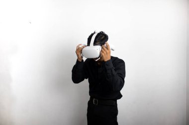 Siyah gömlekli genç adam sanal gerçeklik kulaklığı kullanıyor. Beyaz arka plan stüdyo resminde izole edilmiş. VR, gelecek, cihazlar, teknoloji, çevrimiçi eğitim, öğrenme, video oyunu konsepti