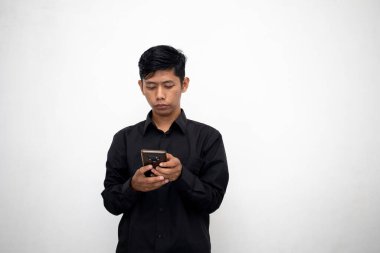 Siyahlı Asyalı adam beyaz arka planda akıllı telefon tutuyor.