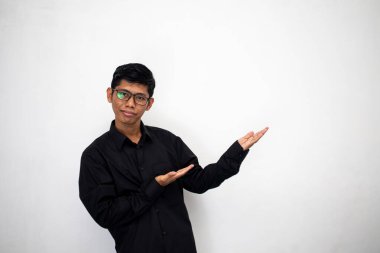 Siyah tişörtlü genç Asyalı adam ürün metni için boş bir alanda bir şeyler gösteriyor.