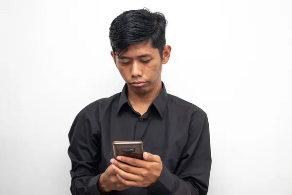 亚洲黑衣人拿着一部白色背景的智能手机 图库图片