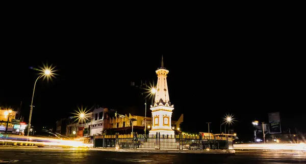 Yogyakarta, Endonezya - 14 Ocak 2024: Motosiklet ve arabaların hafif efektleriyle geceleyin Tugu Jogja. Tugu Yogyakarta 'da yavaş çekim tekniği.