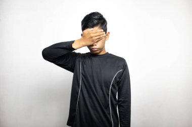 Siyah elbiseli duygusal Asyalı adam beyaz stüdyo arka planında poz veriyor. 