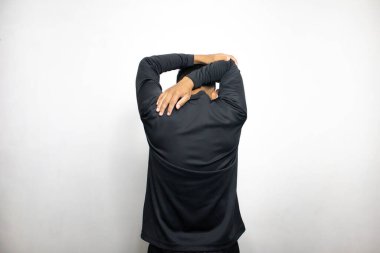 Siyah elbiseli Asyalı bir adamın beyaz stüdyo arka planında duruşu. 