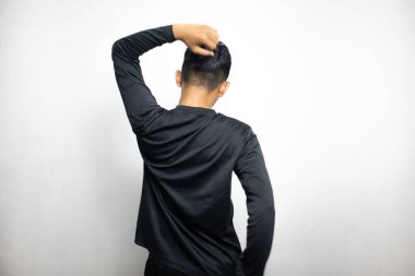 Siyah elbiseli Asyalı bir adamın beyaz stüdyo arka planında duruşu. 