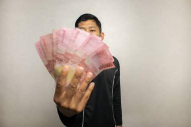 Siyah elbiseli yakışıklı Asyalı bir adam. Elinde yığınla para, beyaz stüdyo geçmişi var. 