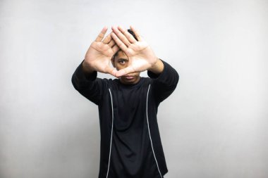 Siyah elbiseli duygusal Asyalı adam beyaz stüdyo arka planında poz veriyor. 