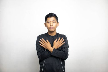 Siyah elbiseli duygusal Asyalı adam beyaz stüdyo arka planında poz veriyor. 