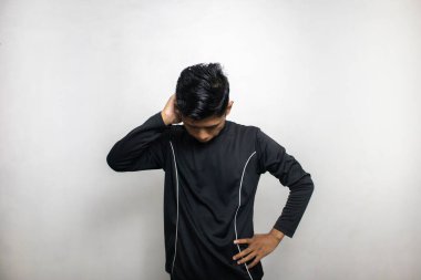 Siyah elbiseli duygusal Asyalı adam beyaz stüdyo arka planında poz veriyor. 