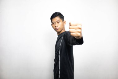 Siyah elbiseli duygusal Asyalı adam beyaz stüdyo arka planında poz veriyor. 