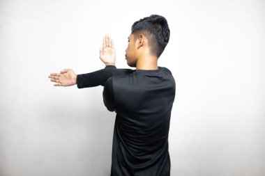 Siyah elbiseli Asyalı bir adamın beyaz stüdyo arka planında duruşu. 