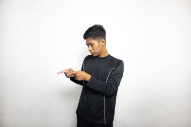 Siyah elbiseli duygusal Asyalı adam beyaz stüdyo arka planında poz veriyor. 