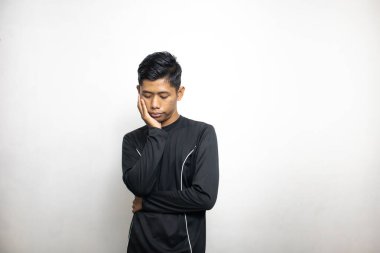 Siyah elbiseli duygusal Asyalı adam beyaz stüdyo arka planında poz veriyor. 