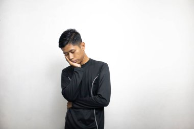 Siyah elbiseli duygusal Asyalı adam beyaz stüdyo arka planında poz veriyor. 