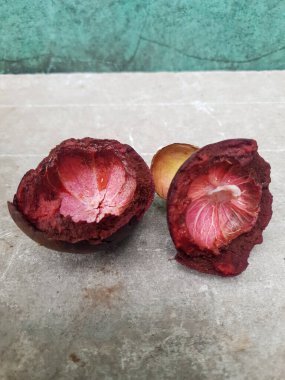 Mangosteen ve enine kesitler, mangosteen meyvelerinin kraliçesinin kalın mor derisini ve beyaz etini gösteriyor. Lezzetli mangosteen meyvesi yakın plan.