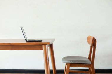 İçerideki ahşap masada dizüstü bilgisayar. 