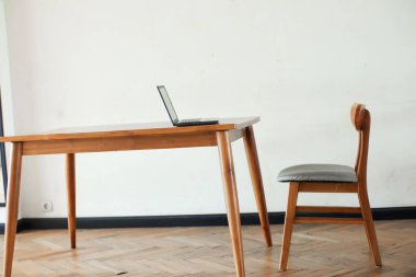 İçerideki ahşap masada dizüstü bilgisayar. 