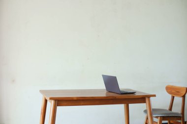 İçerideki ahşap masada dizüstü bilgisayar. 