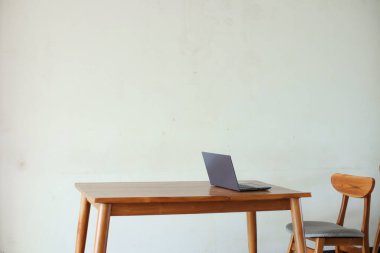 İçerideki ahşap masada dizüstü bilgisayar. 