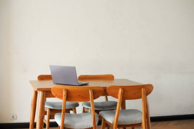 İçerideki ahşap masada dizüstü bilgisayar. 