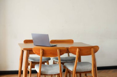 İçerideki ahşap masada dizüstü bilgisayar. 