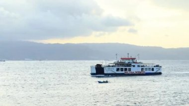 BALI, INDONEZYA - 19 Temmuz 2024: Bali 'ye yolcu taşıyan büyük bir gemi mavi denizde büyük dalgalarla karşılaştı.