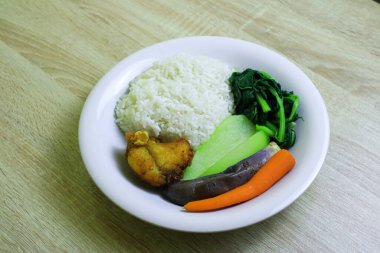 Pilav, sebze ve balık yan yemekleriyle dolu sağlıklı yemek menüsünün en üst görüntüsü.