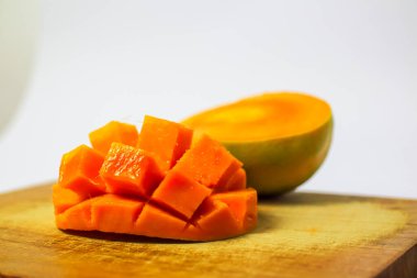 Beyaz arka planda izole edilmiş kesme tahtasındaki olgun mango meyveleri, lezzetli elma mango meyveleri.