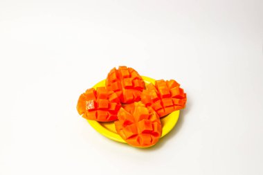 Beyaz arka planda izole edilmiş sarı tabakta dilimlenmiş mango. 
