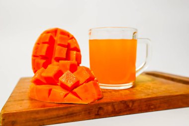 Mango suyu ve mango dilimleri beyaz arkaplanlı, taze mango suyu.