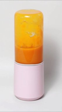 Mango suyu yapımında kullanılan küçük taşınabilir blender, beyaz arka planda taze mango suyu.