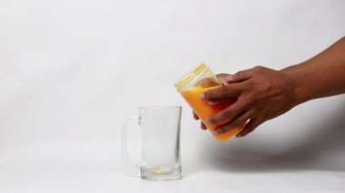 Mango suyu yapımında kullanılan küçük taşınabilir blender, beyaz arka planda taze mango suyu.