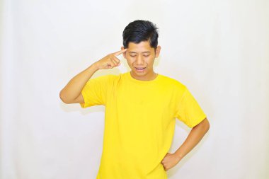 Genç Asyalı adam, izole edilmiş beyaz arka planında parmaklarıyla işaret ediyor.