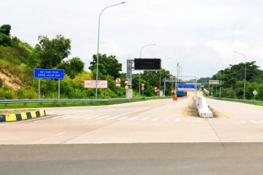 Bakauheni, 17 Ocak 2025, bulutlu bir günde yol işaretleri, beton bariyerler ve yeşil bitki örtüsü olan bir otoyol manzarası