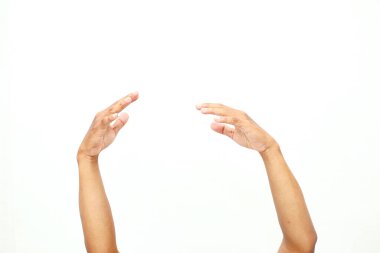 İki elini yavaşça yukarı uzatarak, beyaz bir arkaplana karşı bir teklif ya da davet hissi yaratıyor.