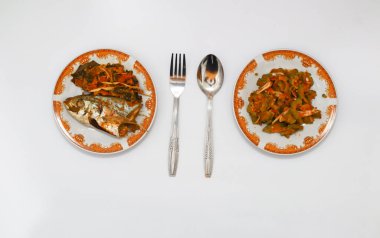 Kızarmış balık ve kavrulmuş acı kavun masada. 