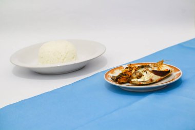 Buğulanmış balık ve beyaz pirinç masada. 