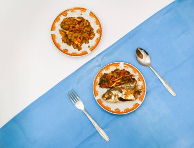 Kızarmış balık ve kavrulmuş acı kavun masada. 