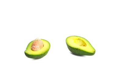 İki avokado yarım, biri tohumlu, temiz, parlak beyaz bir arkaplanda izole edilmiş..
