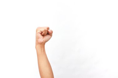 Güçlü bir kolun yakın plan çekimi beyaz bir zemine karşı sıkılmış bir yumrukla havaya kaldırıldı.